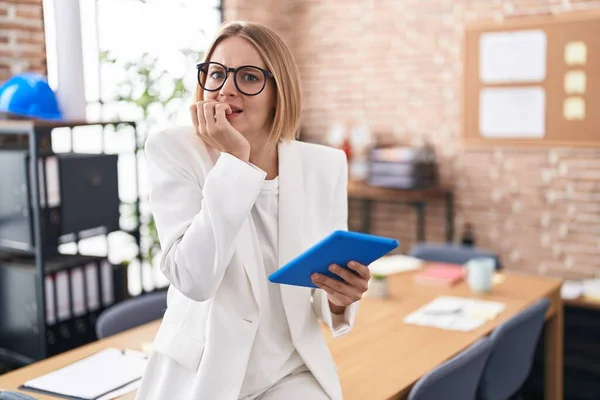 オフィスで働く若い白人女性は 口の中で爪をかむ上で手でストレスと緊張を見て眼鏡をかけています 不安の問題 — ストック写真