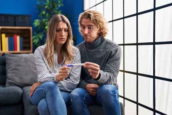 Young Couple Holding Pregnancy Test Result Skeptic Nervous Frowning Upset — Stockfoto