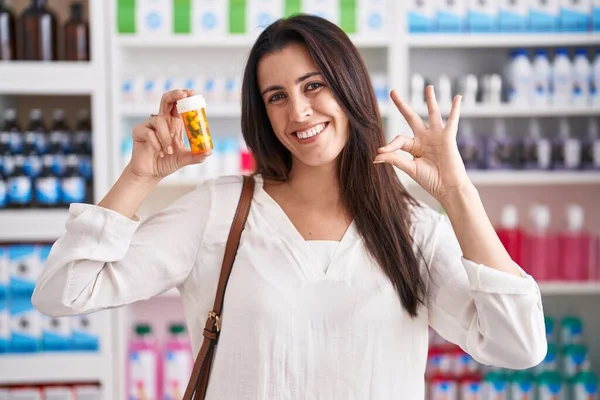 Молодая Брюнетка Женщина Покупки Аптеке Держа Таблетки Делает Хорошо Знак — стоковое фото