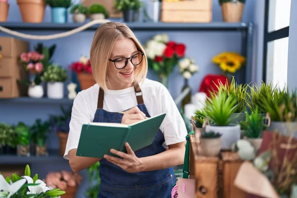 Young Blonde Woman Florist Smiling Confident Writing Notebook Florist Shop — Stock Photo, Image