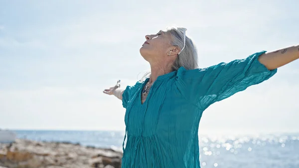 Medelålders Gråhårig Kvinna Andas Med Armarna Öppna Stranden — Stockfoto