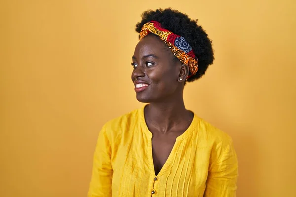 アフリカのターバンを身に着けているアフリカの若い女性は 顔に笑顔で横に離れて見て 自然な表情 自信を持って — ストック写真