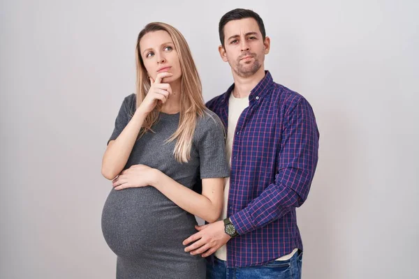 Casal Jovem Esperando Bebê Sobre Fundo Branco Olhando Confiante Para — Fotografia de Stock