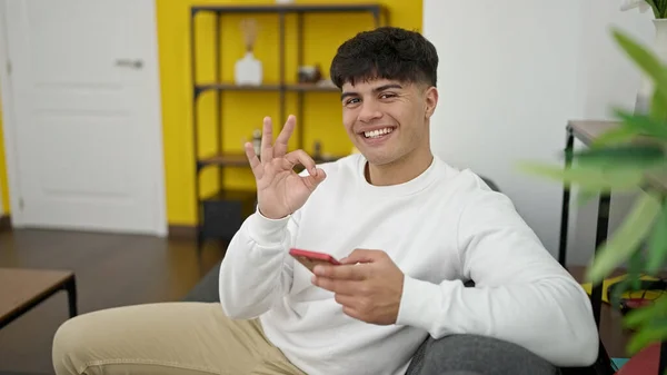 Young Hispanic Man Using Smartphone Doing Gesture Home — Foto de Stock