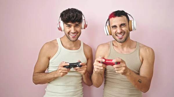 Δύο Άνδρες Χαμογελώντας Σίγουροι Παίζοντας Βιντεοπαιχνίδι Πάνω Από Απομονωμένο Ροζ — Φωτογραφία Αρχείου