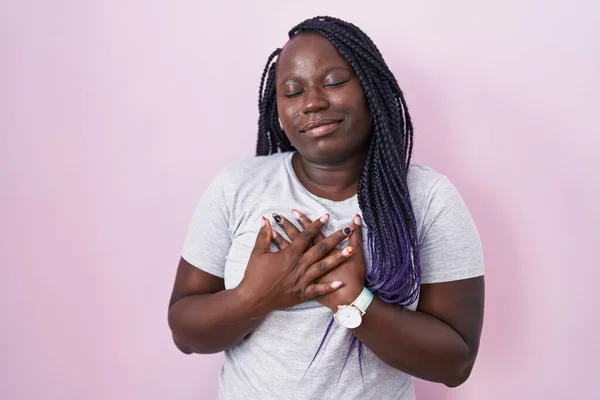 Jonge Afrikaanse Vrouw Staat Roze Achtergrond Glimlachend Met Handen Borst — Stockfoto