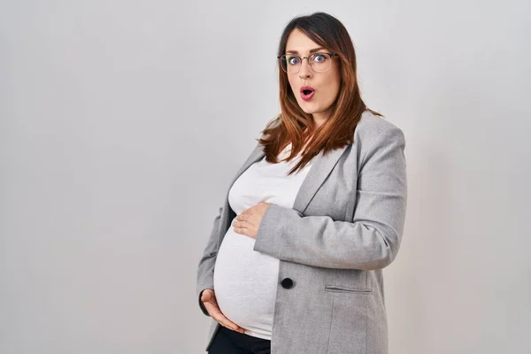 Těhotná Obchodní Žena Stojící Nad Bílým Pozadím Vyděšený Ohromený Otevřenými — Stock fotografie