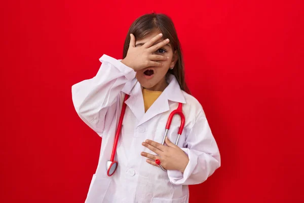 Klein Latijns Meisje Draagt Doktersuniform Stethoscoop Gluurt Shock Bedekt Gezicht — Stockfoto