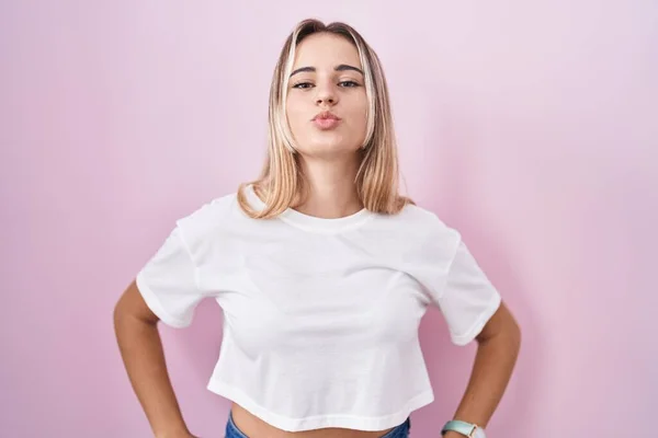 Young Blonde Woman Standing Pink Background Looking Camera Blowing Kiss — Stockfoto
