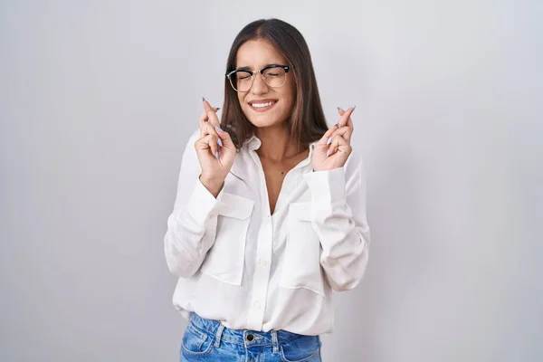 Mujer Morena Joven Con Gafas Haciendo Gestos Con Dedo Cruzados —  Fotos de Stock