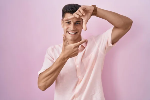 Junger Hispanischer Mann Der Vor Rosa Hintergrund Steht Und Lächelt — Stockfoto