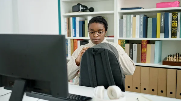 在图书馆大学使用计算机打开背包的非裔美国女学生 — 图库照片