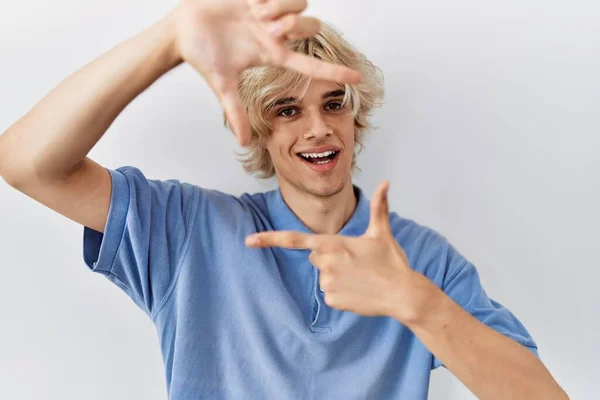 Joven Hombre Moderno Pie Sobre Fondo Aislado Sonriendo Haciendo Marco — Foto de Stock
