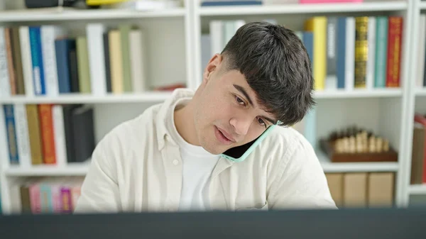 Młody Latynoski Student Korzystający Komputera Rozmawiającego Smartfonie Studiującym Uniwersytecie Bibliotece — Zdjęcie stockowe