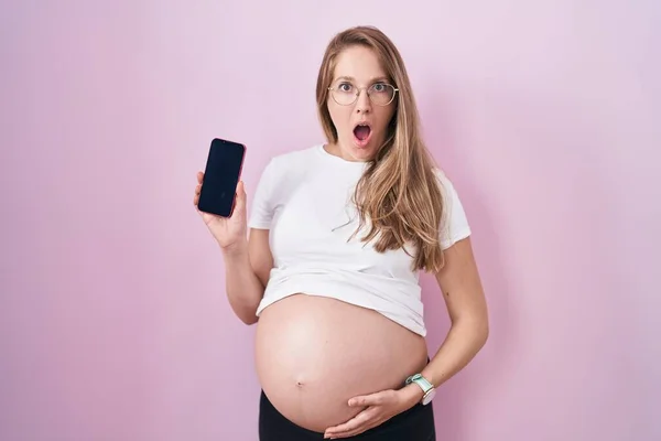 Jonge Zwangere Vrouw Toont Buik Houden Smartphone Bang Geschokt Met — Stockfoto