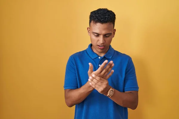 Sarı Arka Planda Dikilen Spanyol Genç Adam Ellerinde Parmaklarında Ağrı — Stok fotoğraf