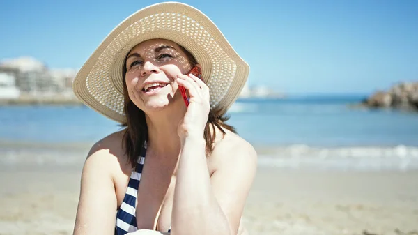 中世のパニック女性観光客日光浴タオルの上に座っているビーチで電話で話す — ストック写真
