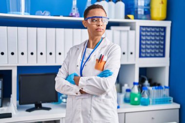 African american woman scientist standing with arms crossed gesture at laboratory