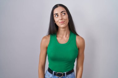 Young woman standing over isolated background smiling looking to the side and staring away thinking. 