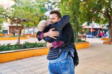 Mother and son smiling confident hugging each other at park