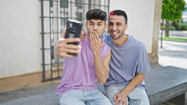 Two men couple smiling confident having video call at street