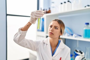 Laboratuvarda test tüpleri tutan genç İspanyol bilim kadını.