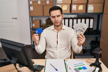 Küçük işletme şirketinde sakallı genç İspanyol bir adam elinde banknotlar, kredi kartı tutuyordu şüpheci ve gergindi, sorun yüzünden surat asıyordu. negatif kişi. 