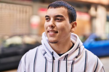 Sokakta kendine güvenen genç adam gülümsüyor