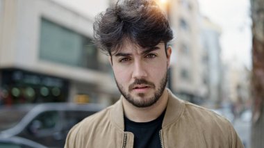 Sokakta ciddi bir ifadeyle duran İspanyol genç adam.