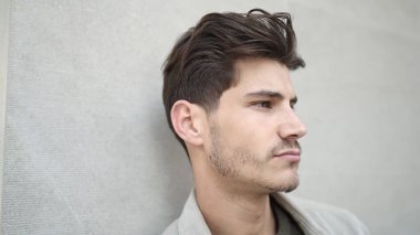 Young hispanic man standing with serious expression over isolated white background