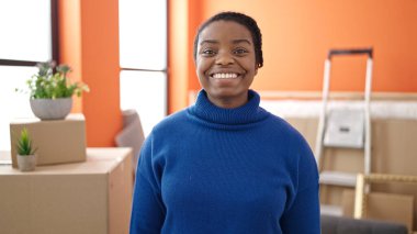 Yeni evinde kendine güvenen Afrikalı Amerikalı kadın gülümsüyor