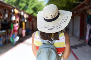 Sokak pazarında yürüyen Asyalı genç bir turist.