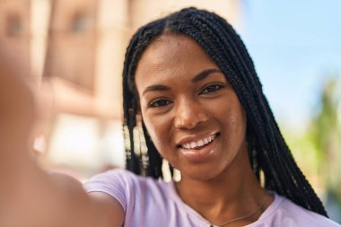 African american woman smiling confident making selfie by the camera at street