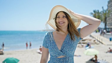 Young blonde woman tourist smiling confident standing at seaside