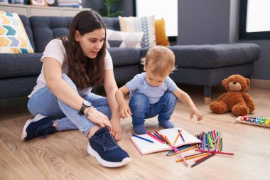 Anne ve oğlu evde oturmuş çizim yapıyorlar.