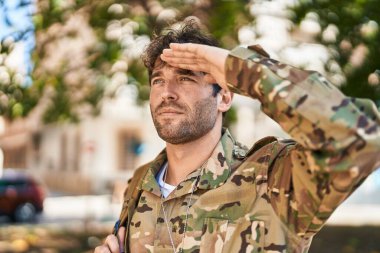 Young man army soldier doing militar salute at park