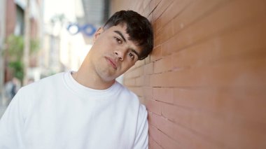 Sokakta ciddi bir ifadeyle duran İspanyol genç adam.