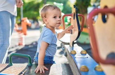 Anne ve oğlu parkta salıncakta sallanıyor.