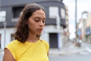 Young african american woman looking to the side with serious expression at street