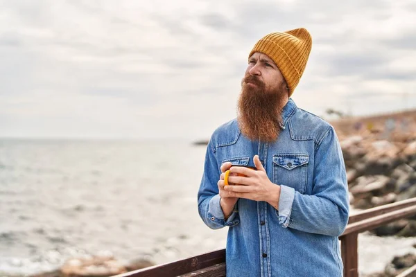 Young Redhead Man Drinking Cup Coffee Serious Expression Seaside — Stock Photo, Image