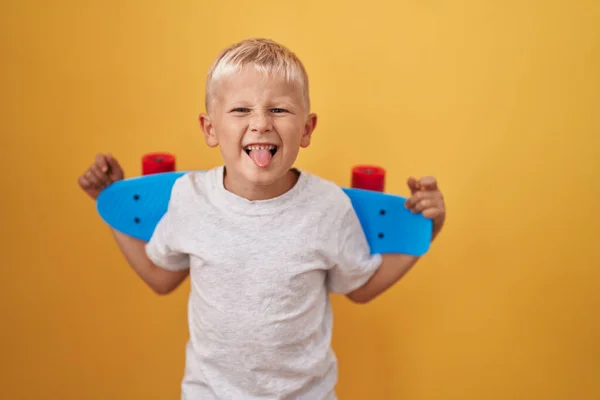 小さなCaucasian男の子保持スケートステッキング舌アウト幸せとともに面白い式 — ストック写真
