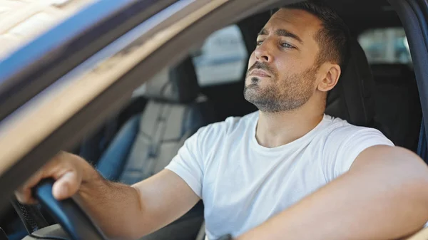 若いヒスパニック系の男が通りで車を運転する — ストック写真