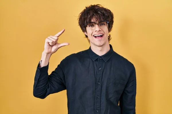 Sarı Arka Planda Gözlük Takan Genç Adam Gülümsüyor Hareketleriyle Küçük — Stok fotoğraf