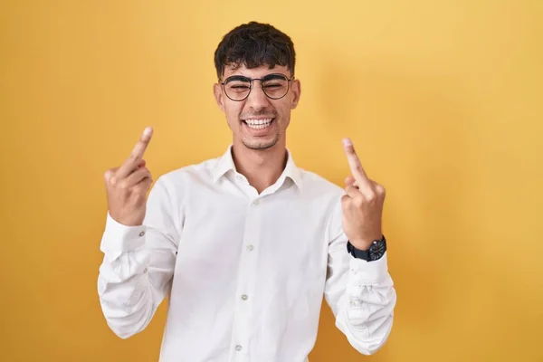 Молодий Іспаномовний Чоловік Стоїть Над Жовтим Тлом Показуючи Середній Палець — стокове фото
