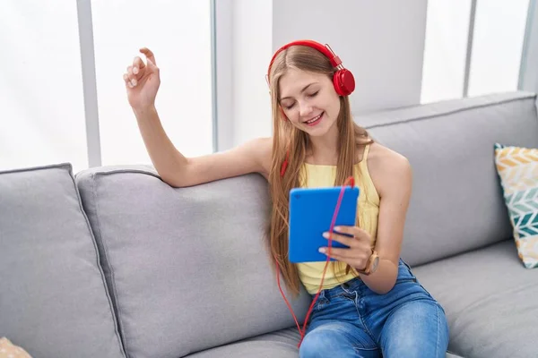 Jonge Kaukasische Vrouw Luisteren Naar Muziek Zitten Bank Thuis — Stockfoto