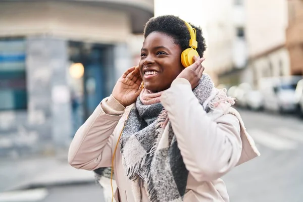 Stock image African american woman smiling confident listening to music at street