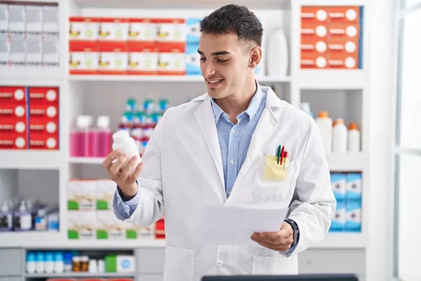 Joven Hombre Hispano Farmacéutico Sosteniendo Pastillas Botella Lectura Prescripción Farmacia —  Fotos de Stock
