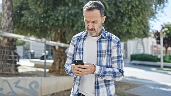 Middelbare Leeftijd Man Met Behulp Van Smartphone Met Serieuze Expressie — Stockfoto