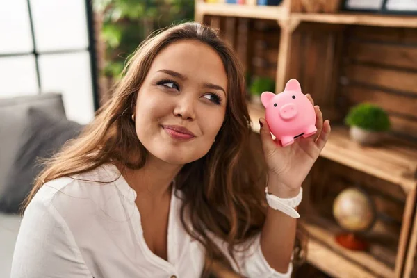 Jong Mooi Latino Vrouw Holding Piggy Bank Zittend Bank Thuis — Stockfoto