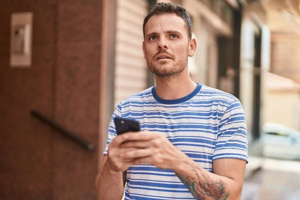 Junger Hispanischer Mann Benutzt Smartphone Mit Ernstem Gesichtsausdruck Auf Der — Stockfoto
